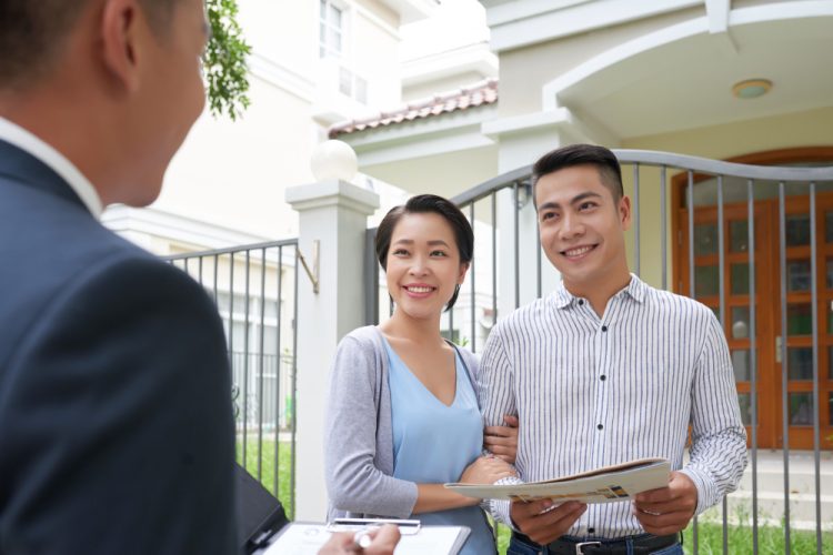 Couple in front of house Couple talking to Rental Experts